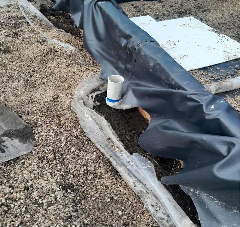 A short 50 mm pipe stub passing out through the liner onto the gravel